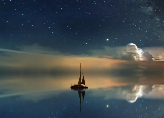 A small sailboat on still water beneath a starry night sky